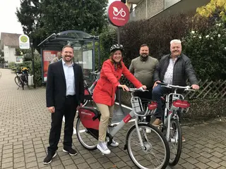 Das Foto zeigt von links nach rechts Gero Zuber (Leiter multimodales Mobilitätsmanagement beim Karlsruher Verkehrsverbund), Monika Müller (Oberbürgermeisterin von Rastatt), Onue Semerci (Nextbike-Manager) und Stefan Lott (Ortsvorsteher von Ottersdorf) bei einem Pressetermin im Rastatter Ortsteil Ottersdorf, bei dem die Erweiterung der nextbike-Flotte in Rastatt vorgestellt wurde. Im Hintergrund ist eine Bushaltestelle zu sehen.