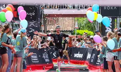 Ein Sportler überquert die Ziellinie beim Triathlon