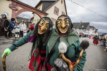 Mitglieder einer Fastnachtsgruppe ziehen als maskierte Hexen durch Hörden