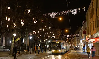 Eine Tram der Linie 1 fährt durch das weihnachtlich beleuchtete Durlach. 