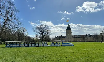 Schlossgartenbahn, blaue Lok fährt fährt vor dem Schloss Karlsruhe