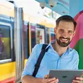 Ein Mann steht lächelnd vor einer Bahn.