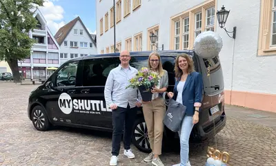 Drei Menschen stehen vor dem KVV.MyShuttle-Bus.