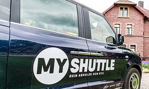 Beifahrertür eines schwarzen "MyShuttle"-Fahrzeuges mit dem Logo des On-Demand-Dienstes.