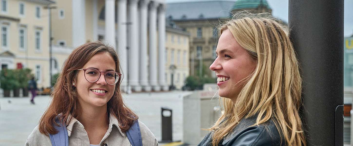 Zwei Studentinnen stehen auf dem Karlsruher Marktplatz.