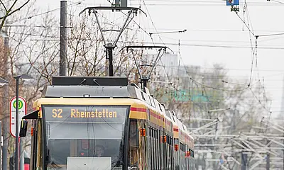 Die Linie S2 zeigt im Zielfilmanzeiger Rheinstetten und fährt eine Haltestelle an.  