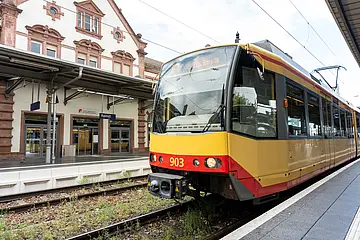 Seitliche Ansicht einer AVG-Stadtbahn, die in Rastatt hält.