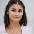 Eine junge Frau wartet an einer Bahn-Haltestelle.