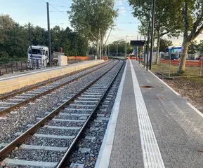 Ein Bahnsteig der modernisierten haltestellen Starkstraße. Daneben ist das geschotterte Gleisbett zu sehen.