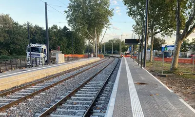 Ein Bahnsteig der modernisierten haltestellen Starkstraße. Daneben ist das geschotterte Gleisbett zu sehen.