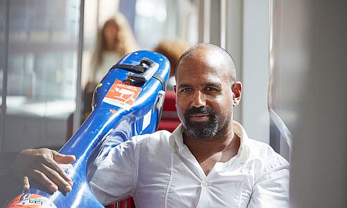 Mann mit einem Cello in einer Straßenbahn.