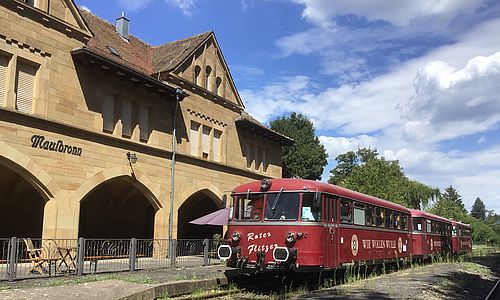 Das historischen Schienenfahrzeug "Kloster-Flitzer" vor einem Bahnhofsgebäude in Maulbronn