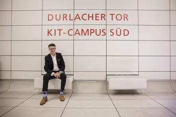 Alexander Pischon sitzt auf einer Bank an der Haltestelle Durlacher Tor/KIT Campus Süd im Stadtbahntunnel Karlsruhe