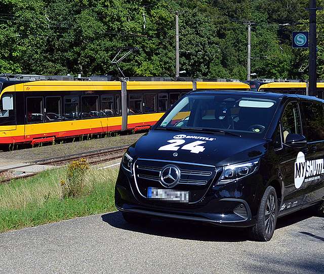 Das KVV.MyShuttle fährt neben einer KVV-Bahn.