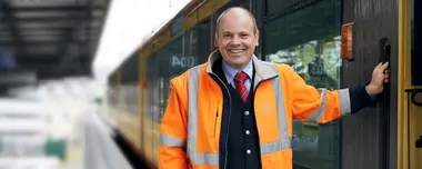 Jochen Dietz steht neben einer AVG-Stadtbahn