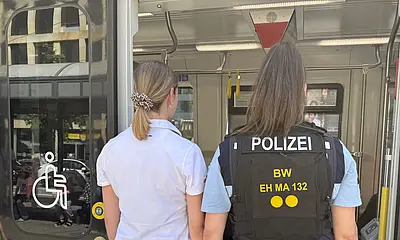 Eine VBK-Kontrolleurin und eine Polizistin betreten eine Straßenbahn der Verkehrsbetriebe Karlsruhe. 