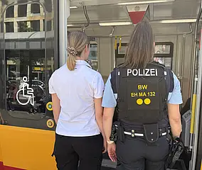 Eine VBK-Kontrolleurin und eine Polizistin betreten eine Straßenbahn der Verkehrsbetriebe Karlsruhe. 