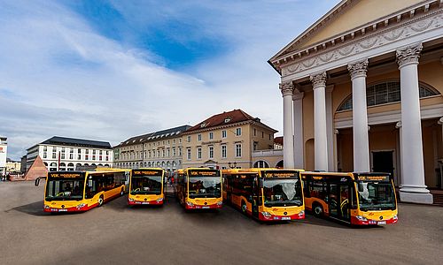 Fünf gelb-rote Busse stehen auf dem Marktplatz in Karlsruhe