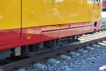 Seitenansicht einer AVG-Stadtbahn auf einem geschottertem Gleisabschnitt