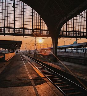 Ein Gleis im Karlsruher Hauptbahnhof vor einer untergehenden Sonne