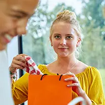 Junge Frau hat eine orange Mappe in der Hand