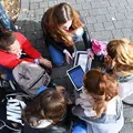 Eine Gruppe Jugendlicher sitzt auf dem Boden. 