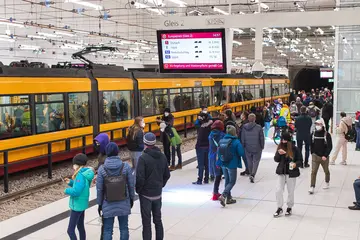 Fahrgäste stehen an einer Haltestelle des Stadtbahntunnels. Eine Bahn fährt in die Haltestelle ein.