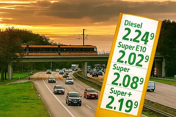 Die Grafik zeigt die Karlsruher Südtangente, auf der Autos fahren. Über die Südtangenete führt eine Brücke, über die eine Stadtbahn fährt. In der rechten Bildhälfte befindet sich eine gelbe Preissäule einer Tankstelle mit hohgen Benzinpreisen über jeweils 2 Euro