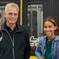 Mädchen in der Bahn zieht einen Stoffschal aus einer Einkaufstüte.