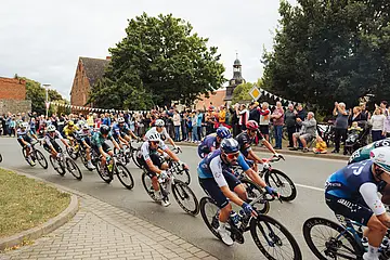 Das Foto zeigt Teilnehmer des Deutschlandtour-Radrennens. Am Streckenrand stehen Zuschauer.
