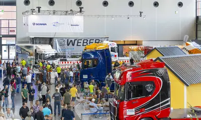 Das Foto zeigt Besucher*innen und ausgestellte Fahrzeuge bei der Nutzfahrzeugmesse NUFAM.