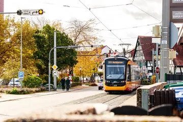Eine Bahn der Linie S1/S11 fährt an eine Haltestelle. 