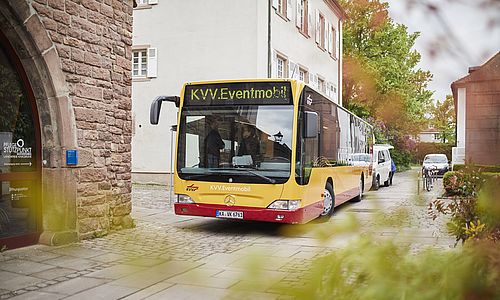 das gelb-rote Eventmobil des Karlsruher Verkehrsverbundesin in einer engen Straße