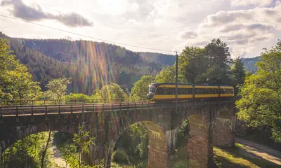 Eine AVG-Stadtbahn überquert ein Viadukt im Murgtal