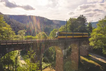 Eine AVG-Stadtbahn überquert ein Viadukt im Murgtal.