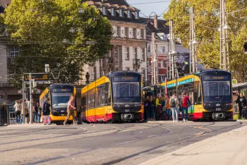 Vorplatz des Karlsruher Hauptbahnhofs mit Bahnen und Fahrgästen