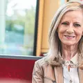 Eine Frau mittleren Alters sitzt in einer KVV-Bahn.