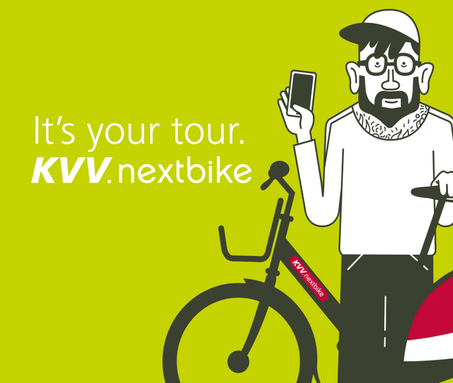 Eine männliche Illustrationsfigur mit Bart auf einem grünen Hintergrund hält in der rechten Hand ein Smartphone und mit der linken Hand ein KVV.Nextbike. Rechts von der Figur befindet sich der Nextbike Claim "It´s your tour"