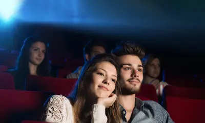 Eine Frau und ein Mann sitzen in einem Kinosaal