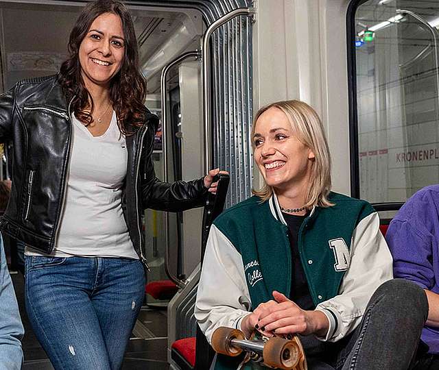 Eine Gruppe junger Menschen unterhält sich in der Bahn.