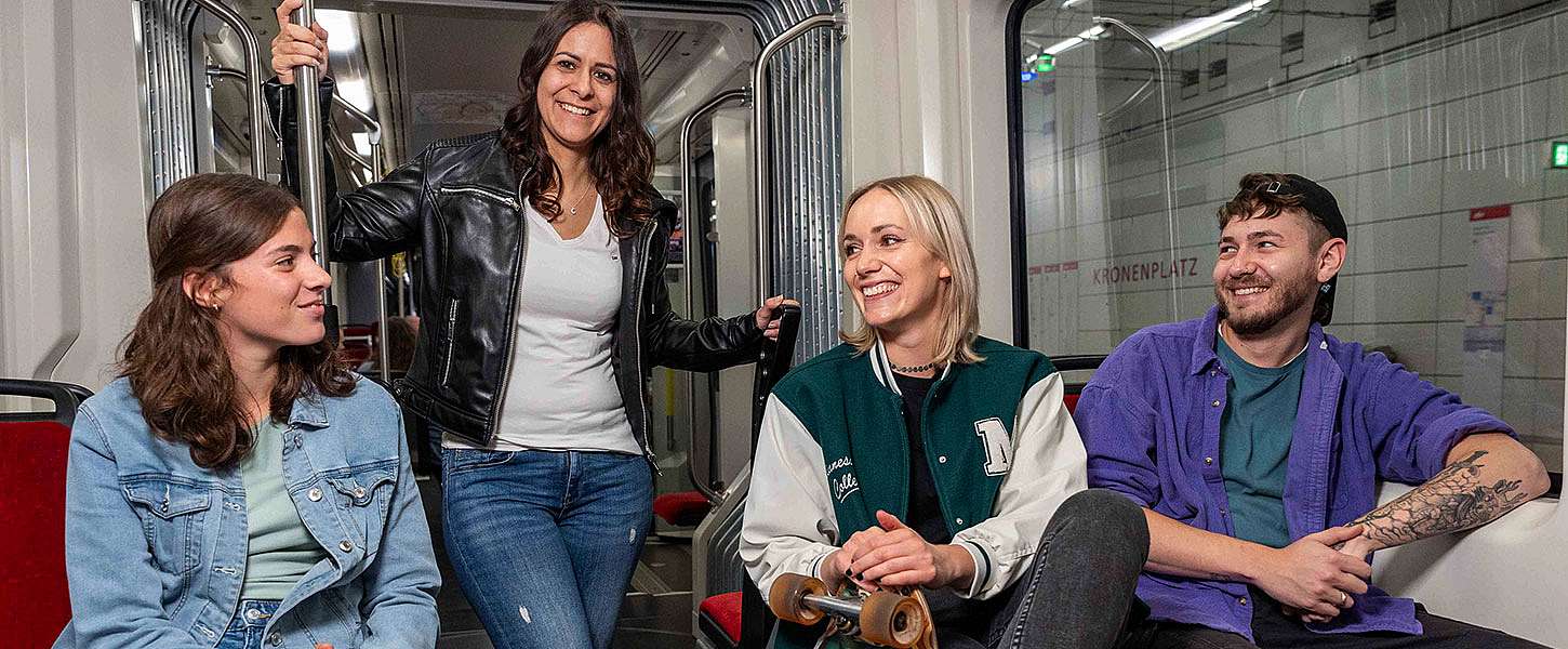 Eine Gruppe junger Menschen unterhält sich in der Bahn.