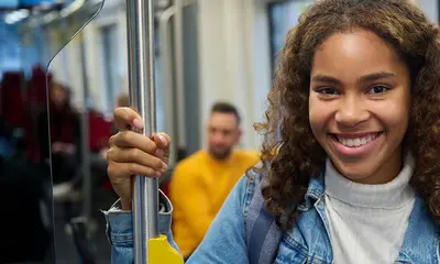 Ein Mädchen hält sich an einer Bahn-Haltestange fest.