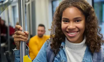Ein Mädchen hält sich an einer Bahn-Haltestange fest.