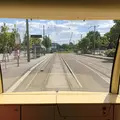 Aus der Frontscheibe der Fahrerkabine einer KVV-Bahn sieht man die zu diesem Zeitpunkt menschenleere Haltestelle Europahalle/Europabad bei sonnigem Wetter.