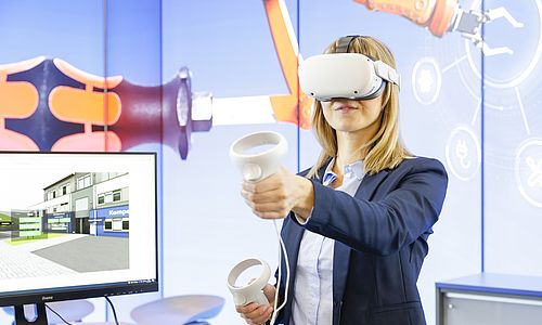 Eine Frau steht an einem Messe-Stand der "Learntec" und trägt eine VR-Brille