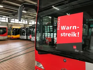 Plakat von ver.di in der Frontscheibe eines Busses zu einem Warnstreik