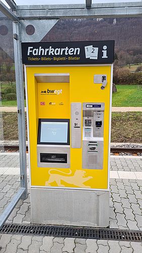 ein schwarz-gelber Fahrkartenautomat an einer Haltestelle