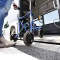 Eine Gehilfe wird in einen Niederflurbus geschoben.