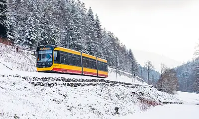 Das Symbolfoto zeigt eine Stadtbahn bei ihrer Fahrt durchs verschneite Albtal.