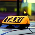 Ein gelbes Taxischild auf dem Dach eines Taxis.